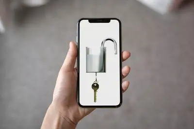 iPhone X com um cadeado desbloqueado e chave na tela