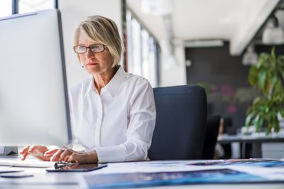 Mulher de negócios usando computador desktop no escritório