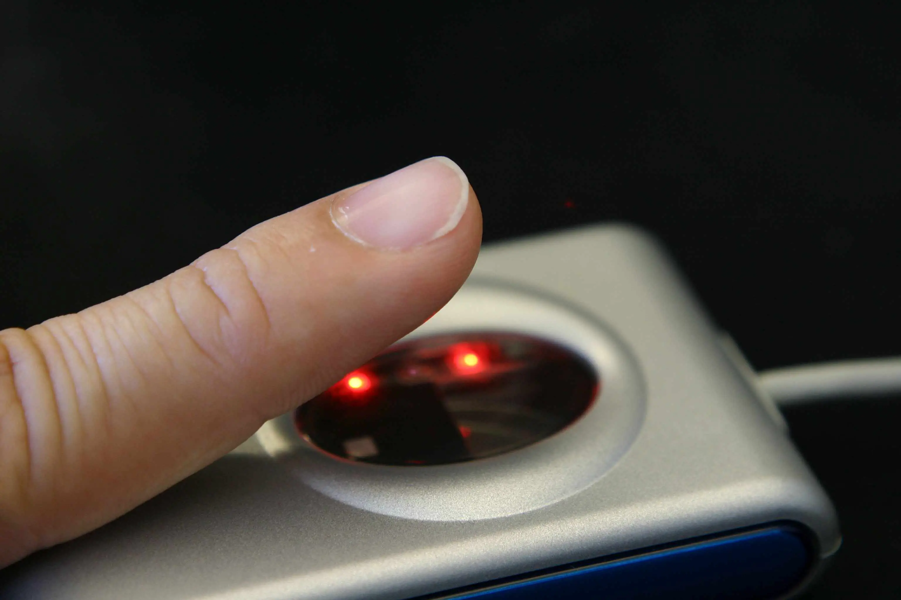 Close de um dedo em um scanner de impressão digital.