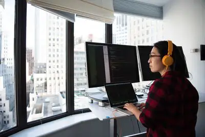 Programador trabalhando em frente a vários computadores