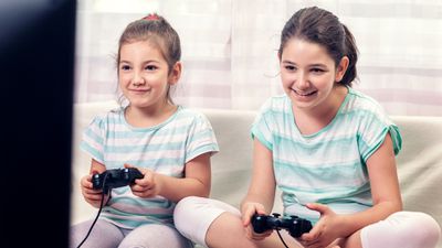 Duas meninas jogando videogames divertidos em seu console PlayStation.