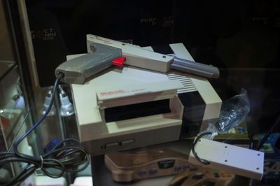 O Nintendo Entertainment System e o NES zapper gun em uma mesa de vidro