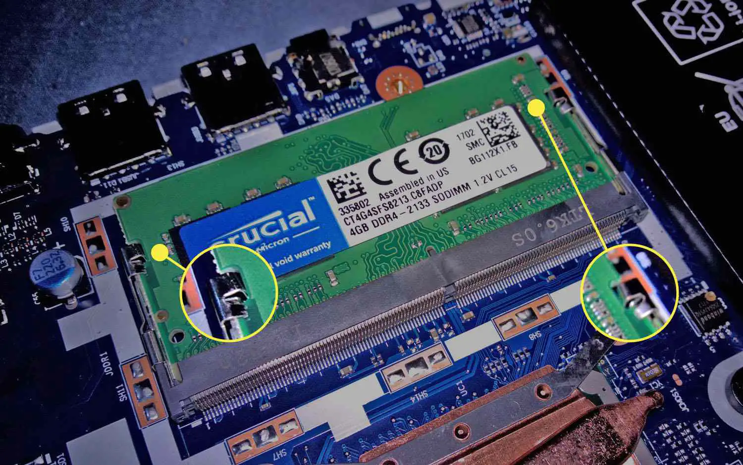 Clipes que prendem um DIMM na placa-mãe de um laptop.