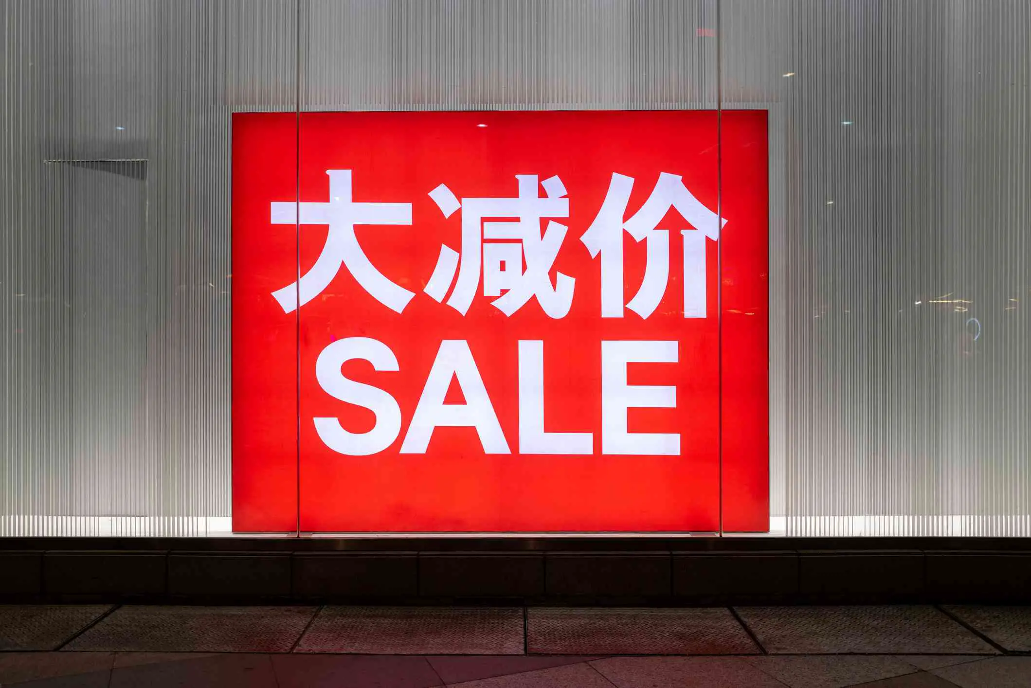 Sinal de vendas vermelho com texto em inglês e chinês
