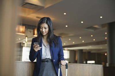 Mulher de negócios usando smartphone no saguão do hotel