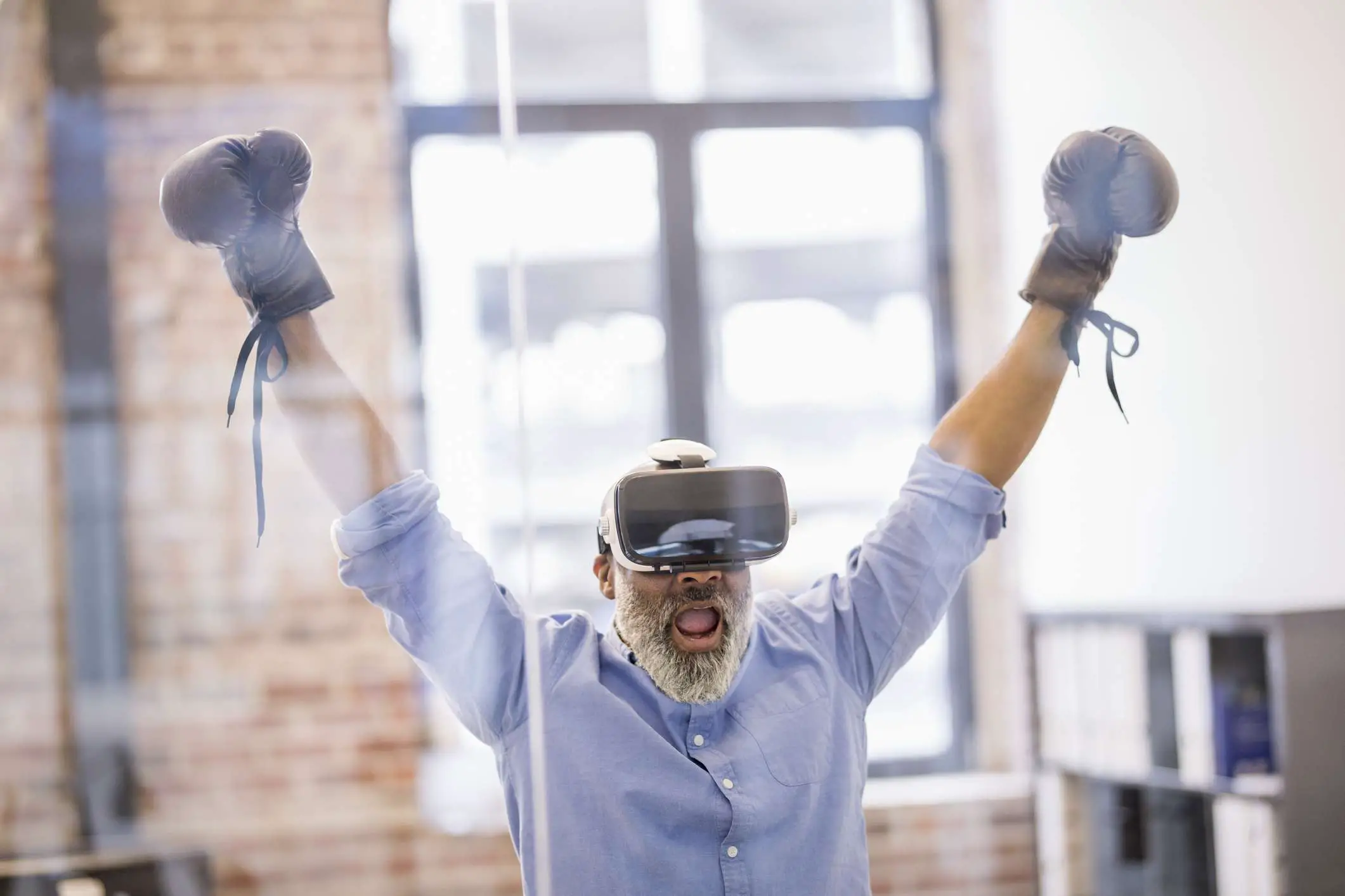 Empresário com óculos de realidade virtual e luvas de boxe no escritório