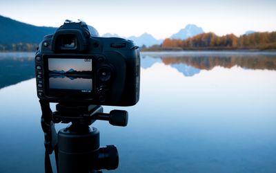 Câmera no tripé capturando lagos e montanhas