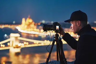 Um fotógrafo tirando uma foto de uma cidade à noite