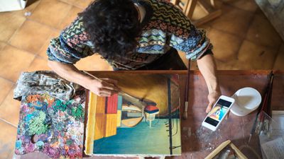Um pintor usando um aplicativo de cores em seu smartphone.