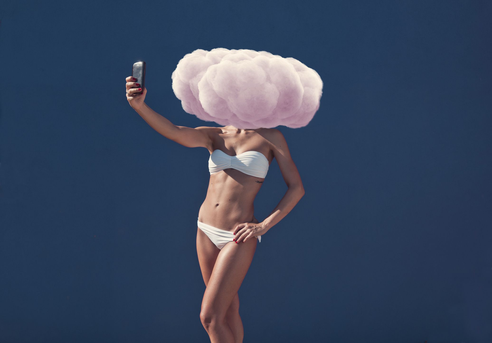 Uma mulher tirando uma selfie com uma nuvem rosa na frente da cabeça