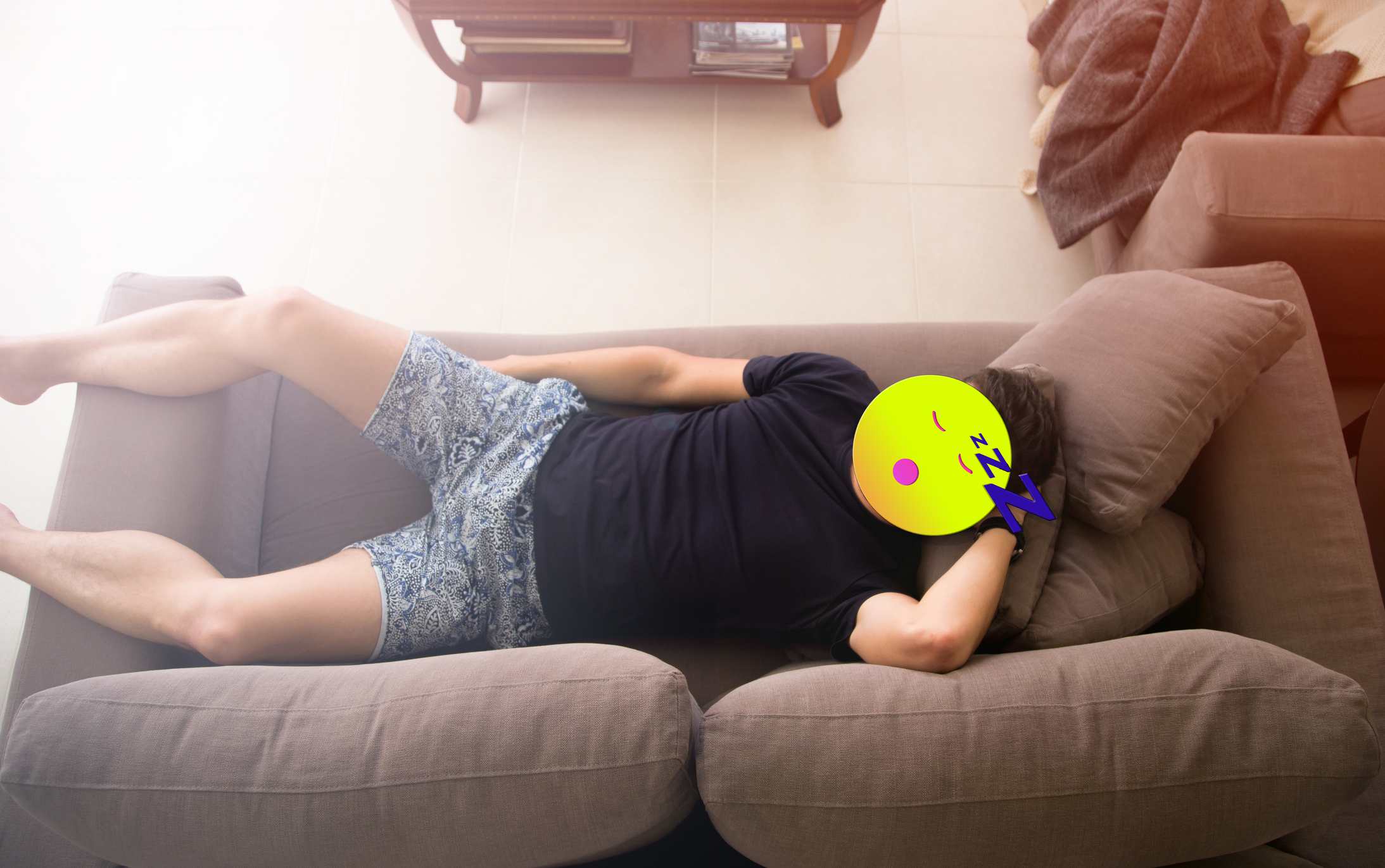 Um homem deitado em um sofá com um emoji na frente de sua cabeça