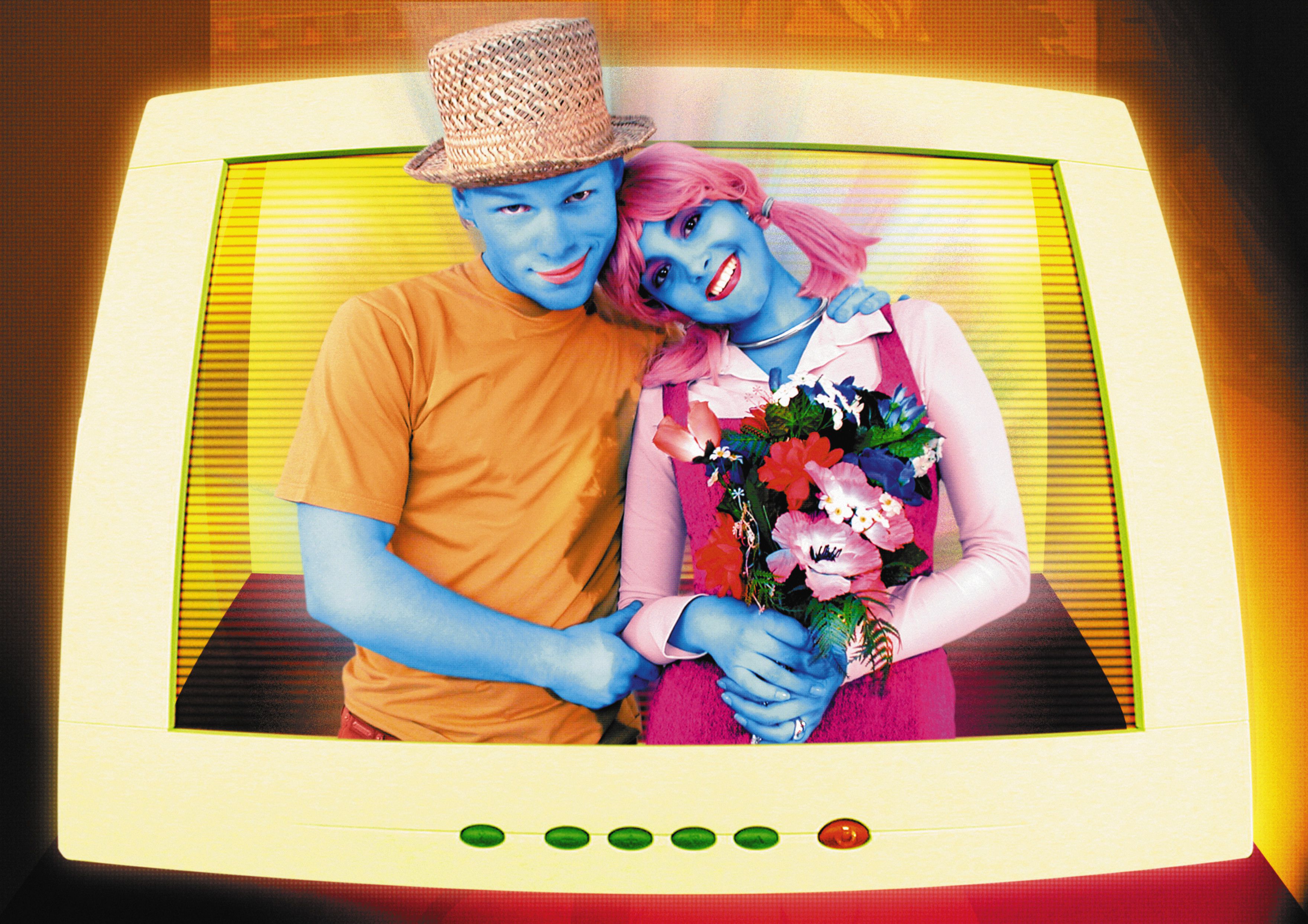 Um casal com maquiagem brilhante saindo da tela de um computador