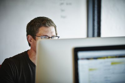 homem de óculos trabalhando no computador