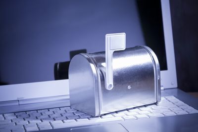 Caixa de correio prateada em miniatura em laptop branco