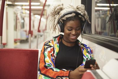 Indo para o trabalho e ouvindo fones de ouvido no metrô