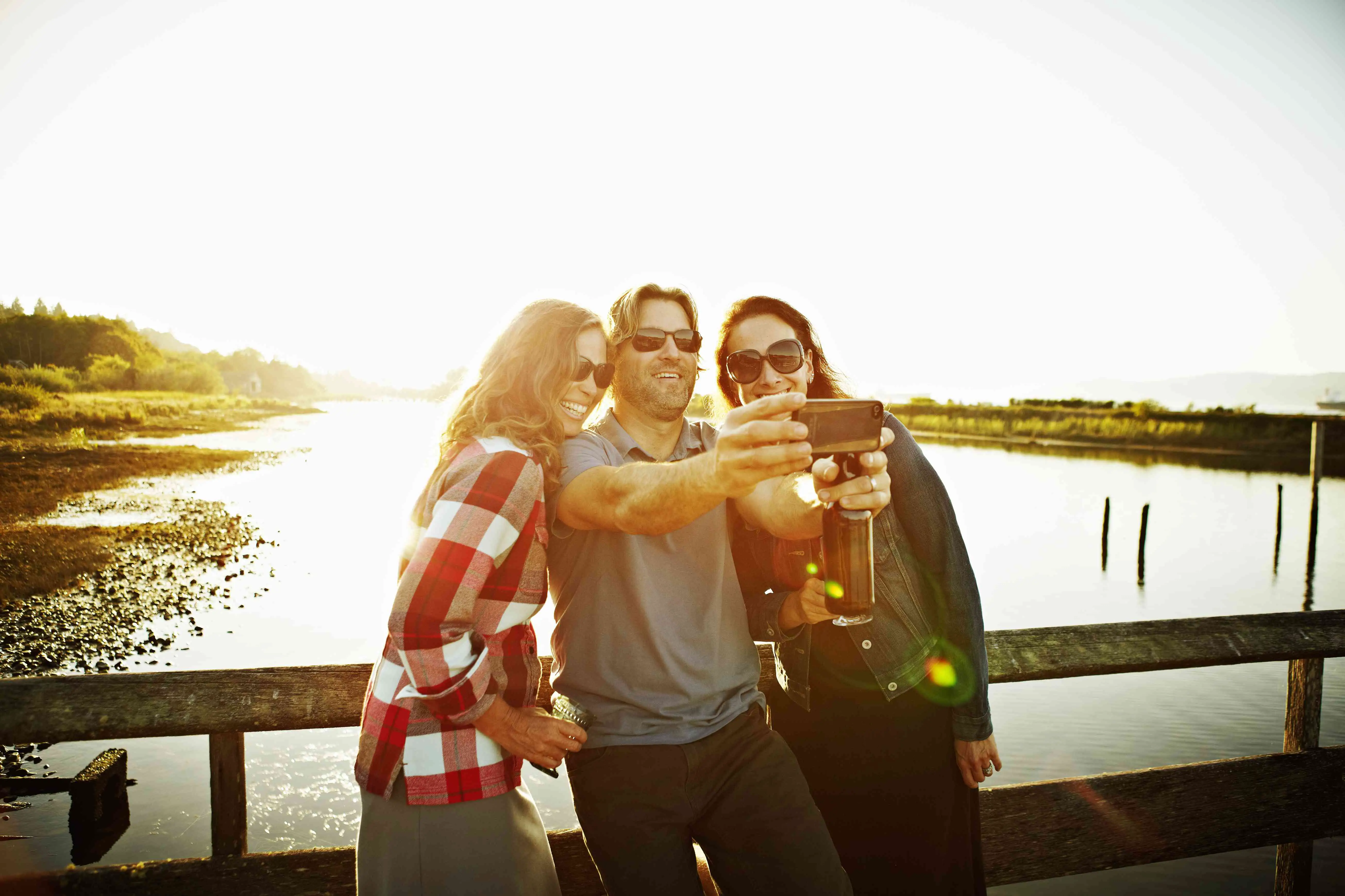Três amigos tirando autorretrato com smartphone