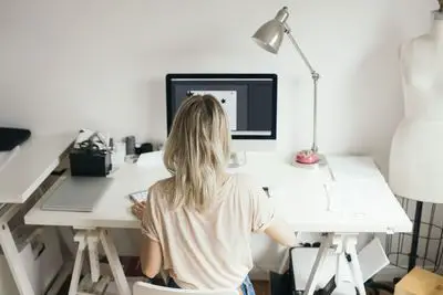 Visão de alto ângulo de profissional de design feminino usando o computador em casa