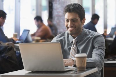 Homem de negócios usando laptop no café