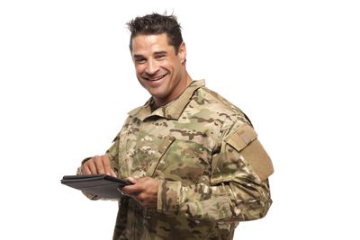 Soldado sorrindo e segurando um tablet nas mãos.