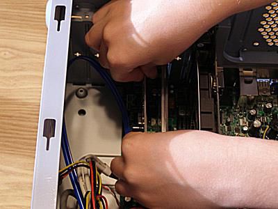 Foto de alguém removendo uma placa de expansão da placa-mãe de um computador