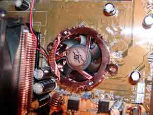 Um ventilador de refrigeração da CPU alinhado sobre os orifícios de montagem da placa-mãe.