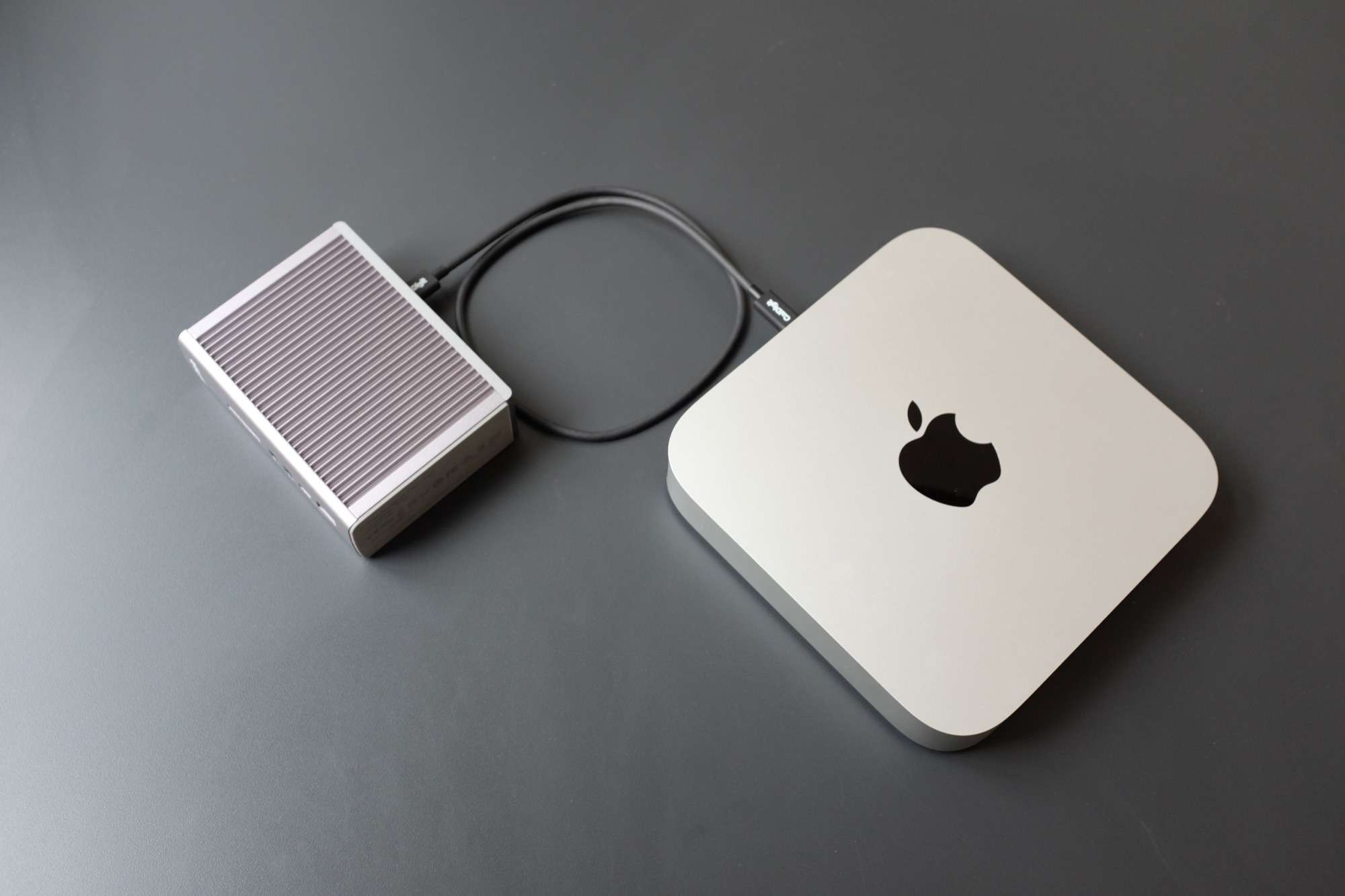 CalDigit TS3 + conectado a um Mac Mini e apoiado em uma mesa cinza