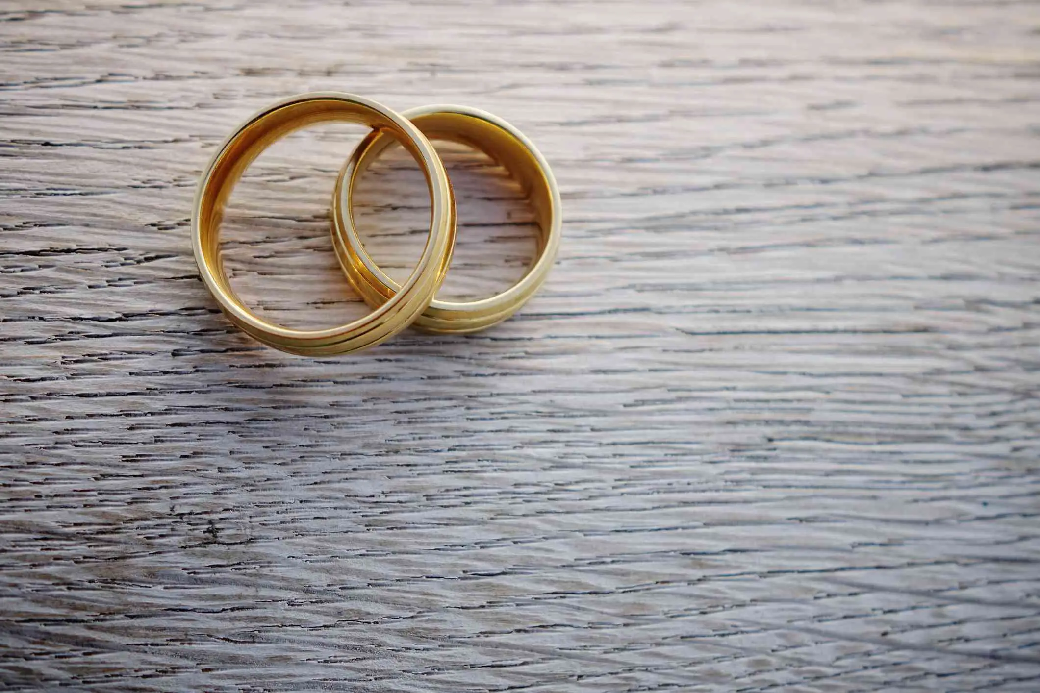 Um par de alianças de ouro simboliza o casamento.  Aprenda a definição sociológica aqui.