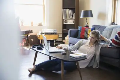 Mulher usando laptop no chão da sala
