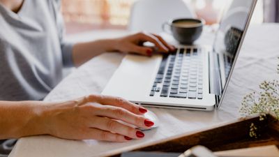 Mulher trabalhando em um laptop com café