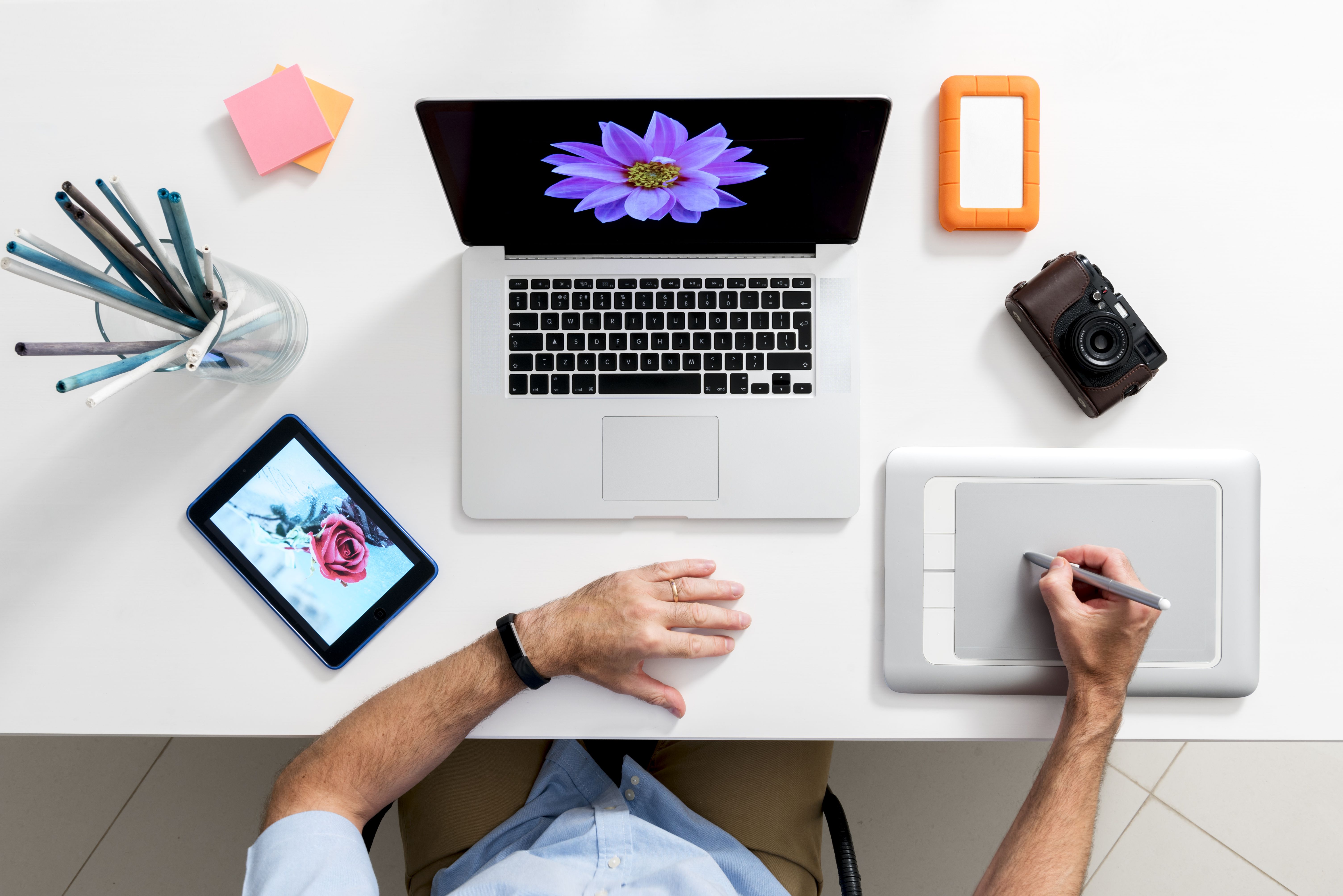 Área de trabalho de um artista moderno com um iPad, MacBook e tablet de desenho