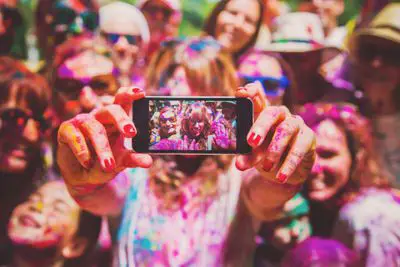 Pessoas cobertas de tinta tirando uma selfie em um iPhone