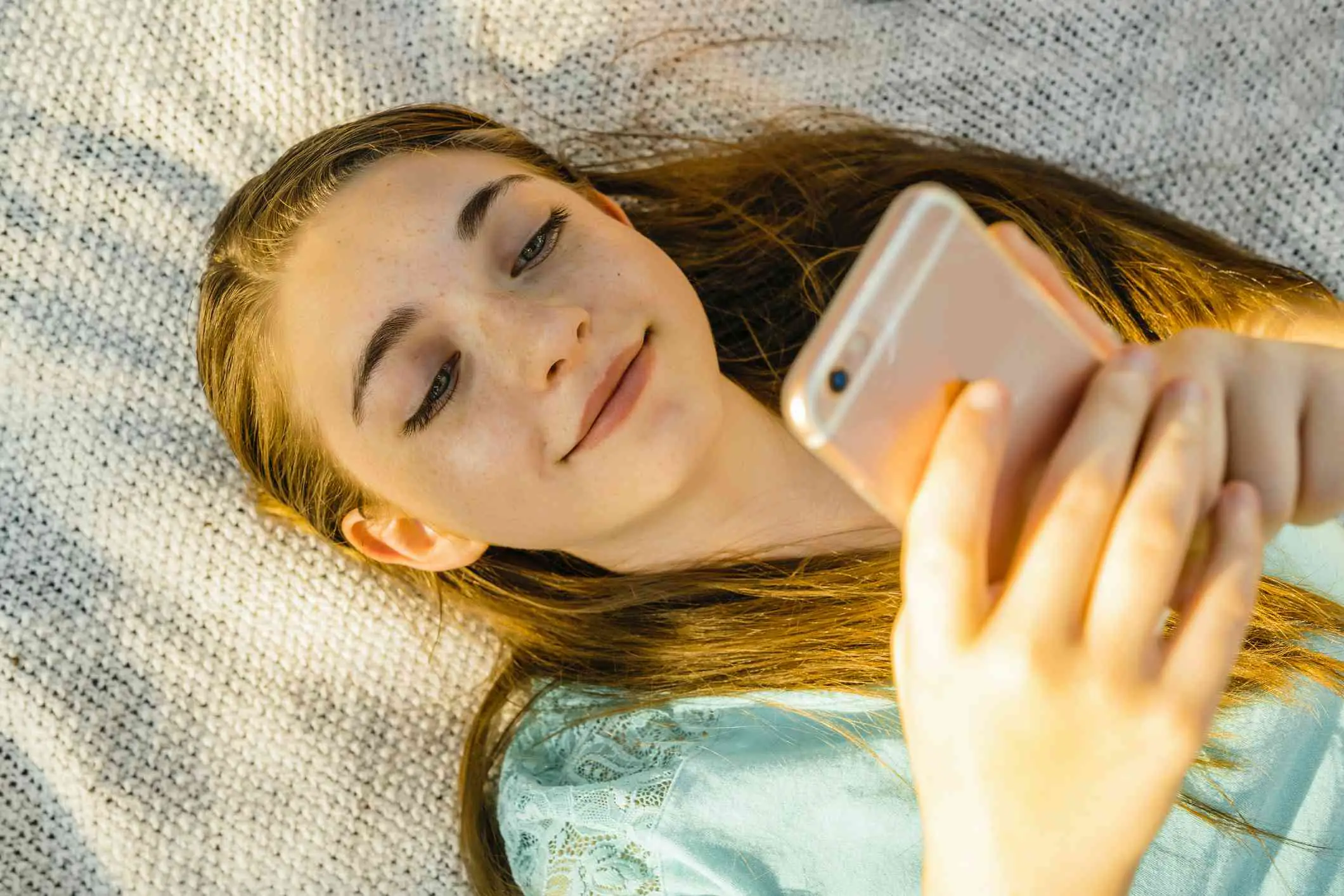 Uma adolescente olhando para seu smartphone.