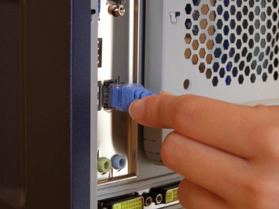 Foto de alguém removendo o cabo de rede de um computador