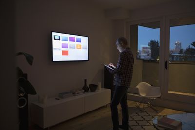 homem controlando Apple TV com iPad