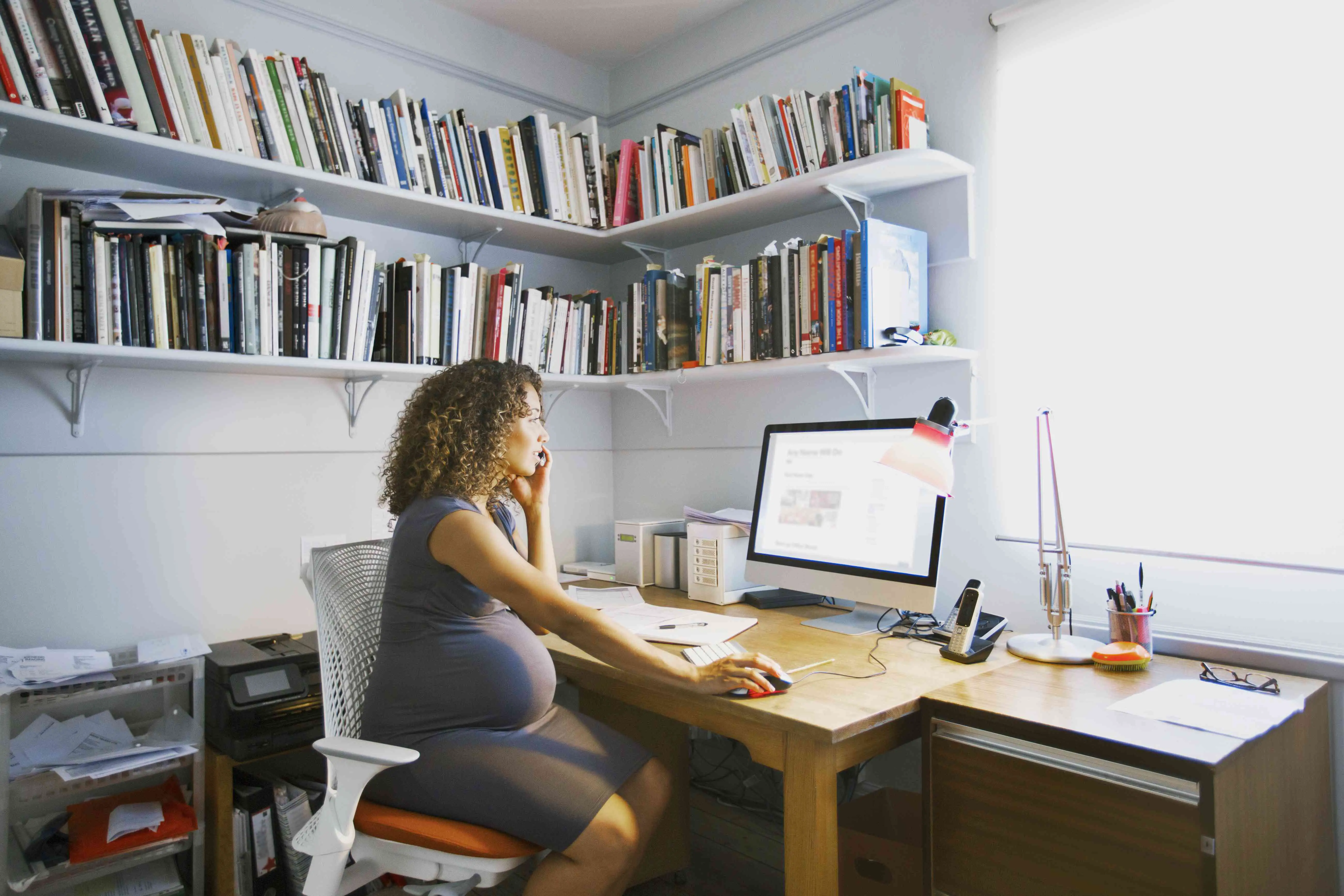 Mulher grávida trabalha em seu escritório em casa