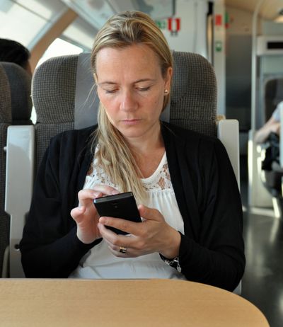 Uma mulher franzindo a testa para seu smartphone