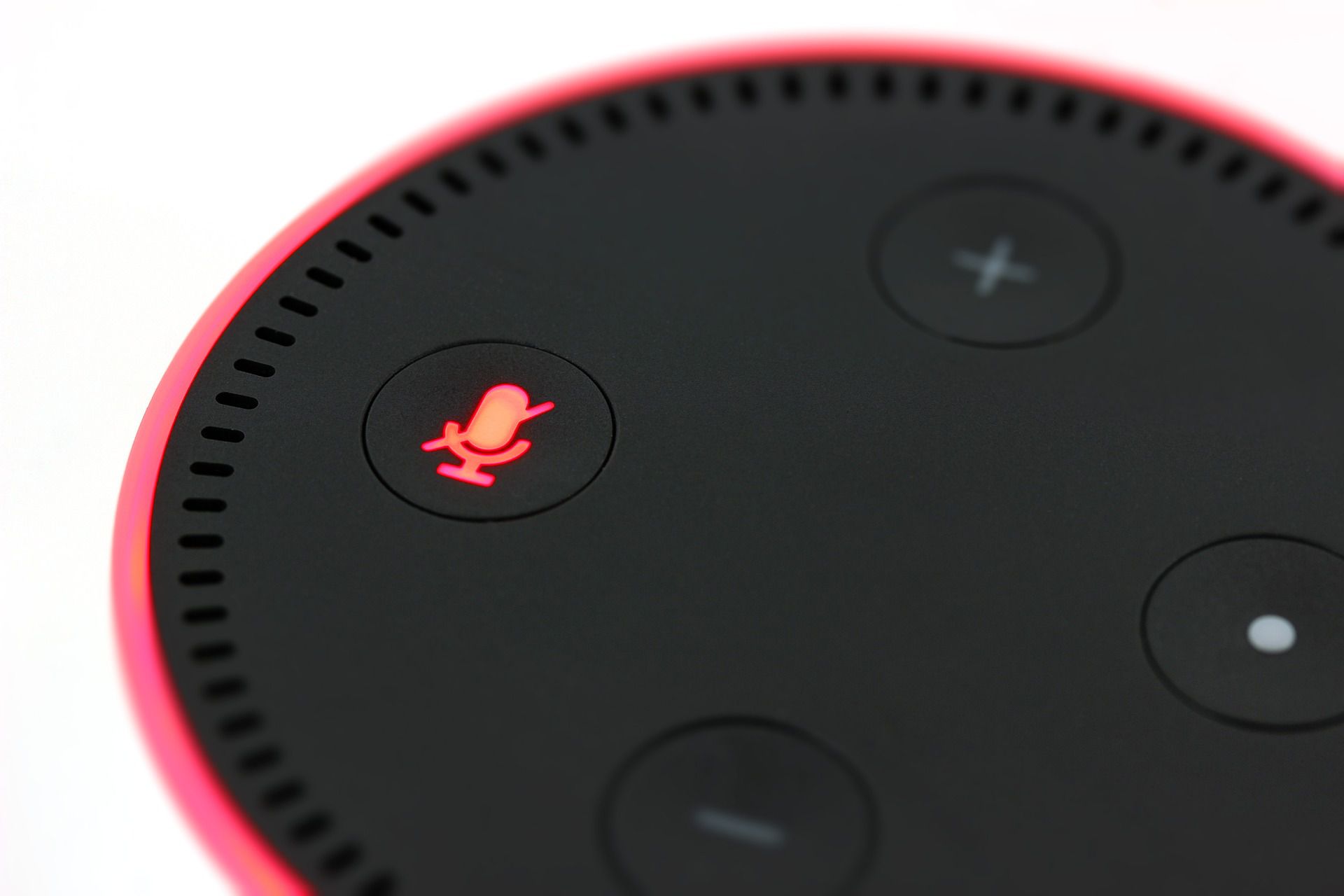 Uma foto de um Amazon Echo com uma luz vermelha piscando.