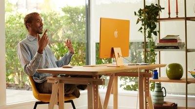 Alguém usando um iMac laranja em um escritório doméstico.