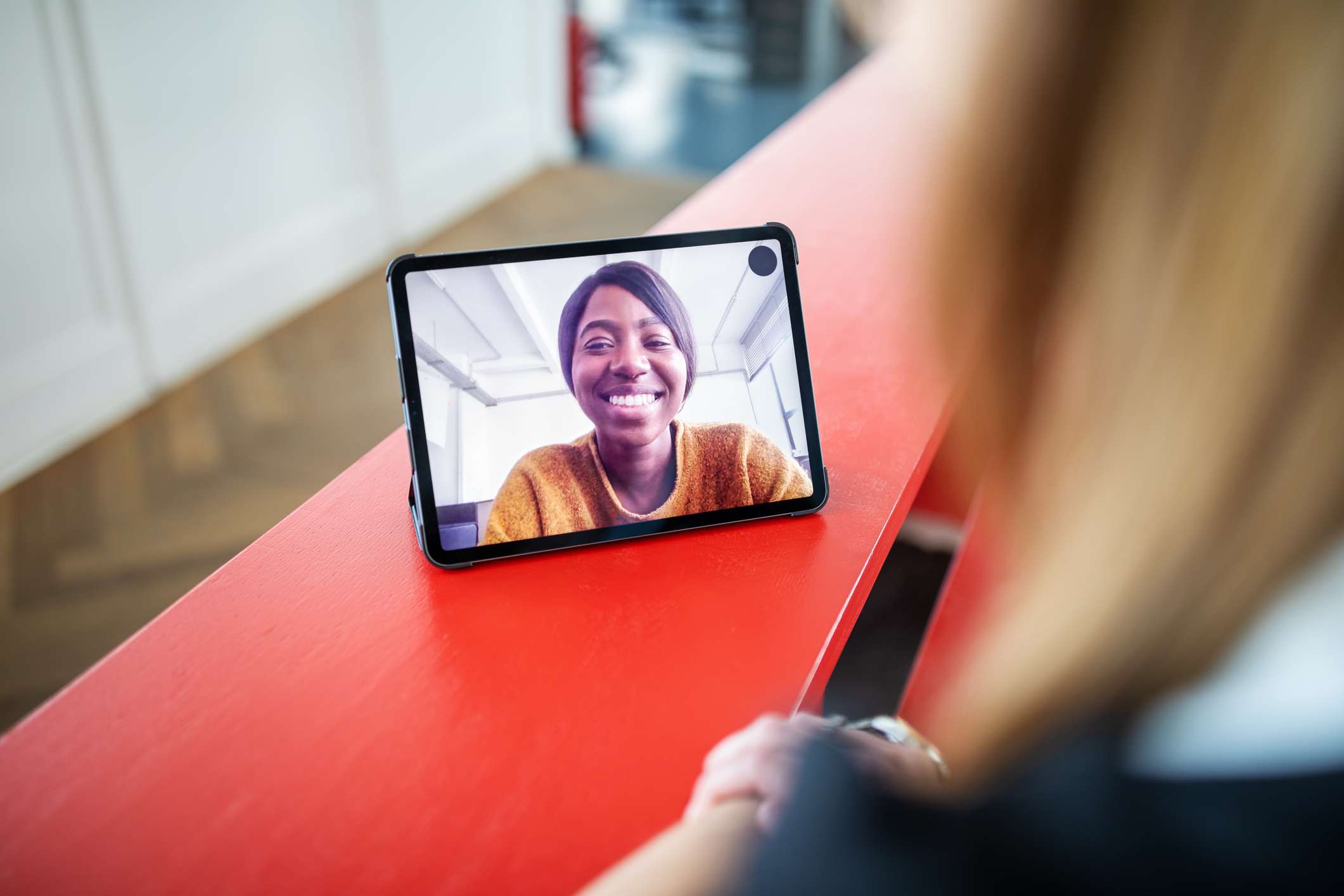 Um tablet em uma mesa exibindo uma chamada de videoconferência