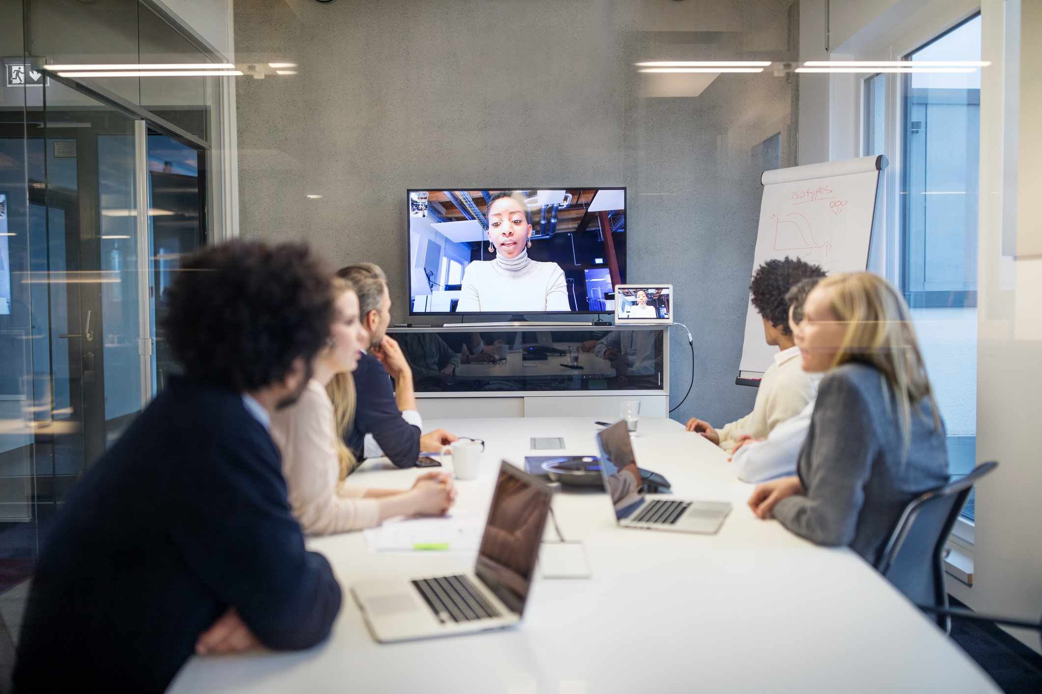 Uma sala de conferências com videoconferência no monitor de parede