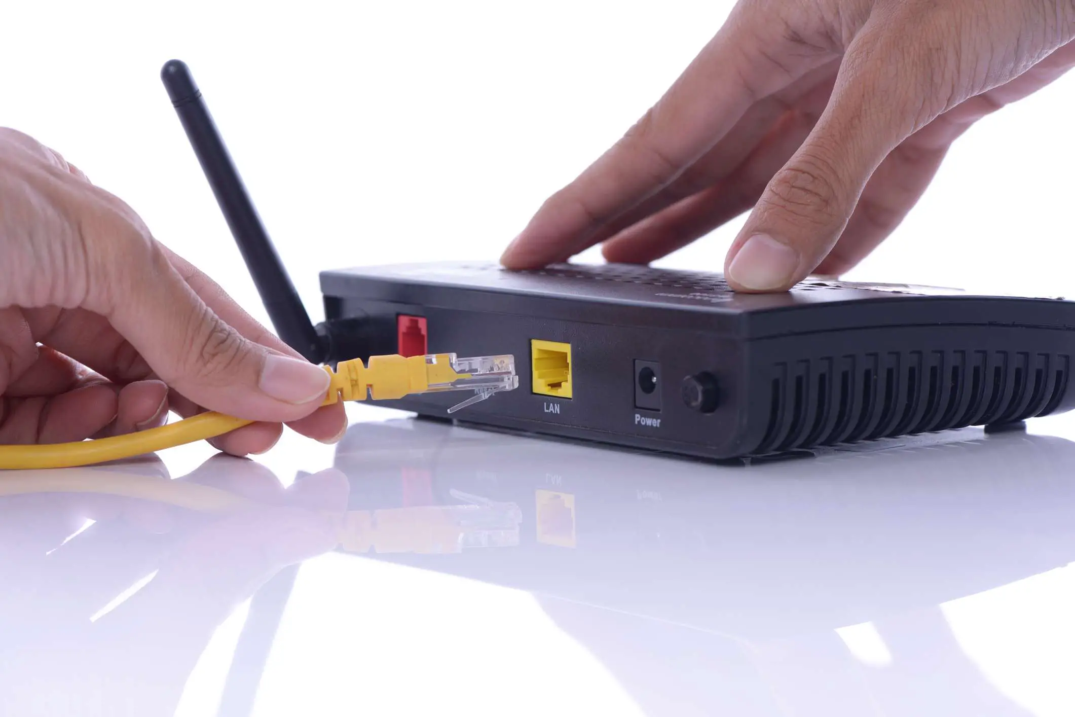 Uma pessoa conectando um cabo Ethernet a um roteador sem fio
