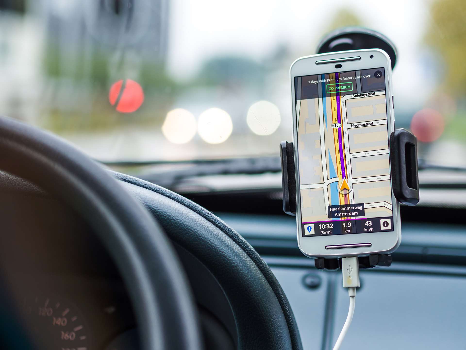 telefone mostrando GPS na tela, montado no para-brisa de um carro