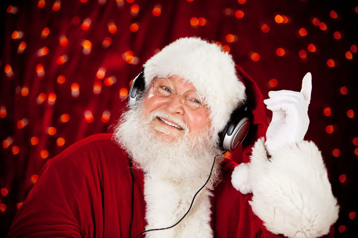 Papai Noel ouvindo música de Natal em fones de ouvido.
