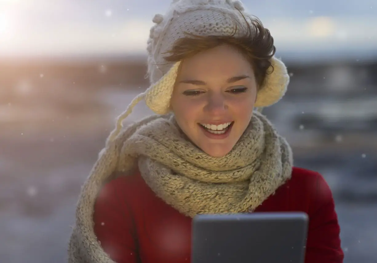 Uma pessoa usando um tablet enquanto está nevando.