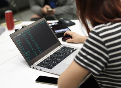 Mulher usando computador com código linux