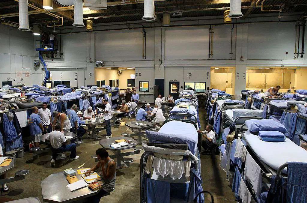 Os presos da Prisão Estadual de Mule Creek interagem em um ginásio que foi modificado para abrigar prisioneiros