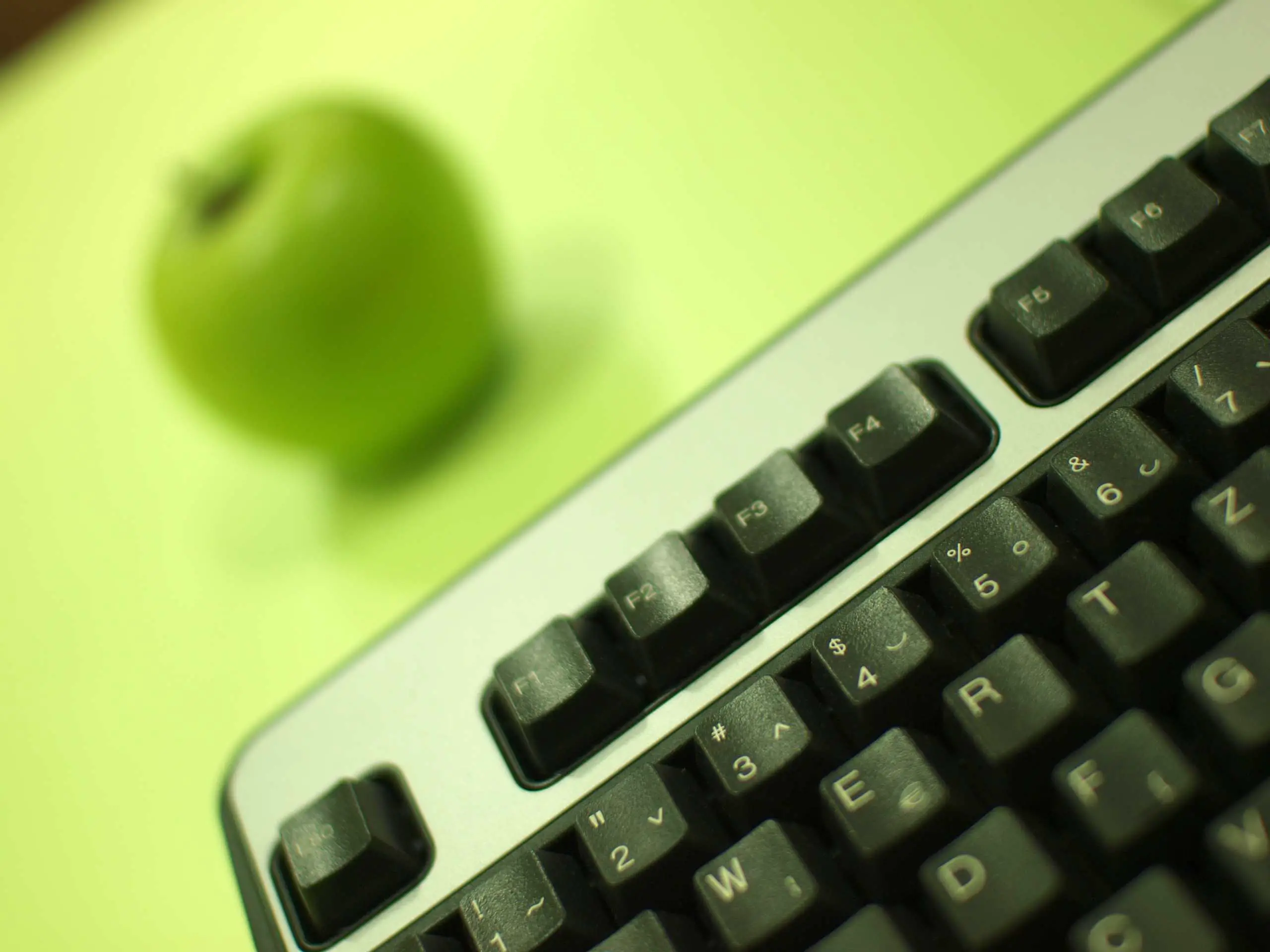 Maçã verde e teclado de computador