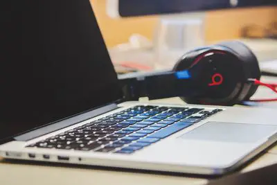 Um par de fones de ouvido Beats ao lado de um laptop