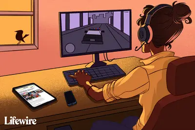Pessoa jogando GTA Vice City em um PC, lendo cheats no Lifewire por meio de um tablet