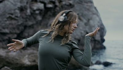 Mulher usando fones de ouvido Bang & Olufsen